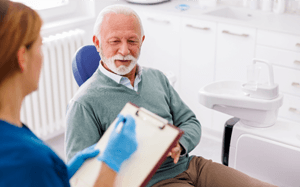 a dental assistant gathering a patient’s medical history