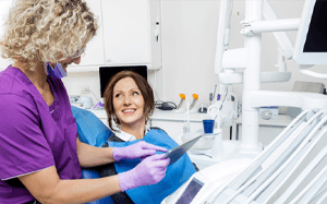a dental assistant showing a patient her X-rays