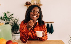 Woman eating yogurt and smiling