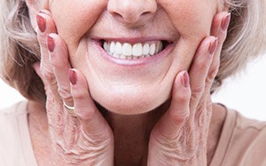 Woman smiling while touching her face
