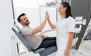 Patient high-fiving dental team member