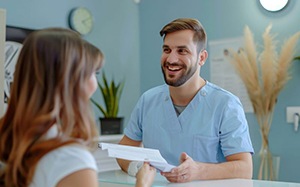 Patient and dental team member discussing paperwork