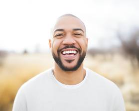 Man in white shirt smiling outside