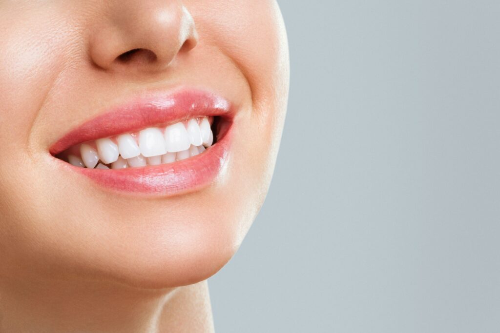 Nose-to-neck view of woman with bright teeth smiling